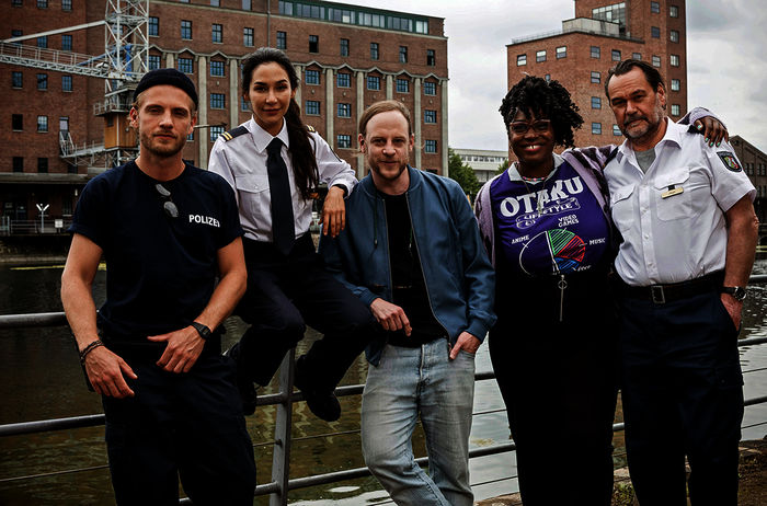 WaPo Duisburg: Frank van Dijk (Niklas Osterloh), Arda Turan (Yasemin Cetinkaya), Regisseur Matthias Koßmehl, Lena Preser (Romy Vreden) und Gerhard Jäger (Markus John). Bild: Sender / ARD / Martin Valentin Menke