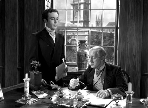 Louis Mazzini (Dennis Price, li.) arbeitet f&uuml;r den liebensw&uuml;rdigen Bankier (Alec Guiness), einer der wenigen aus der Familie, die eines nat&uuml;rlichen Todes sterben. Bild: Sender